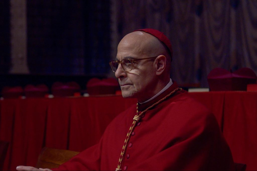 One cardinal wearing a red outfit and a red hat in the movie Conclave, played by Stanley Tucci.