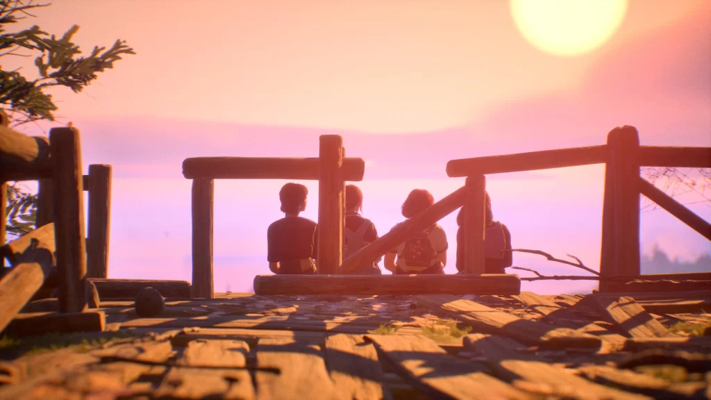 four teenage girls sitting on a dock in front of a sunset