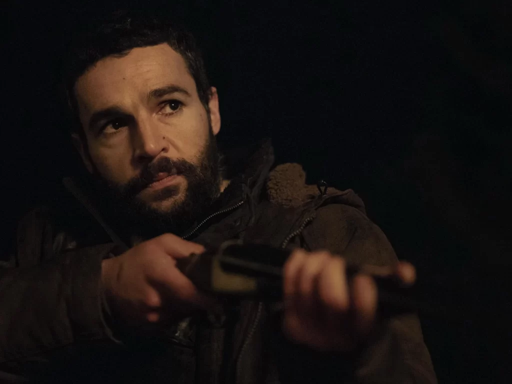 a man looks angry and concerned while holding a shotgun